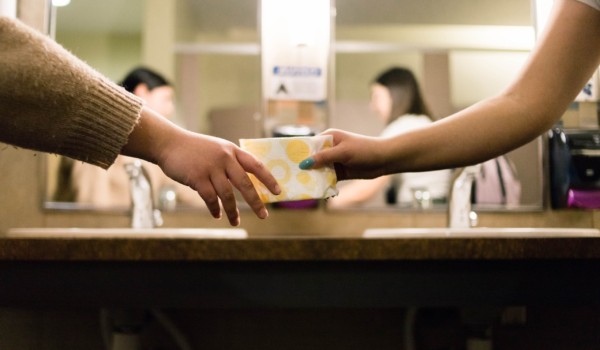 one person passing along a menstrual product to another