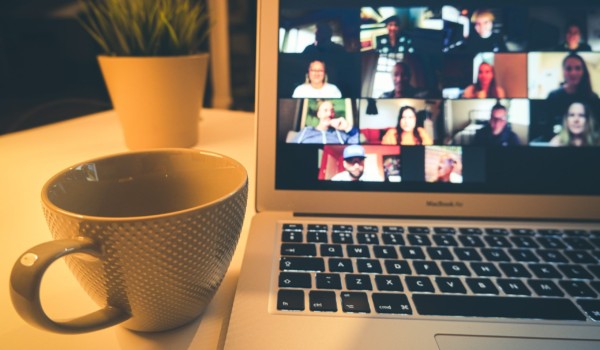 photo of zoom room on laptop screen with coffee mug placed beside it.