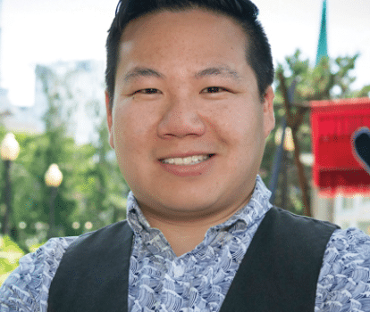 A man in a blue shirt standing outside.