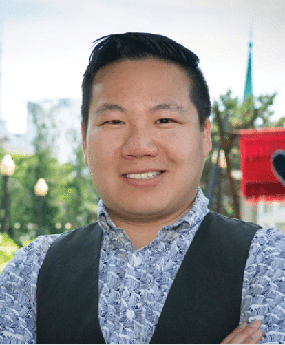 A man in a blue shirt standing outside.
