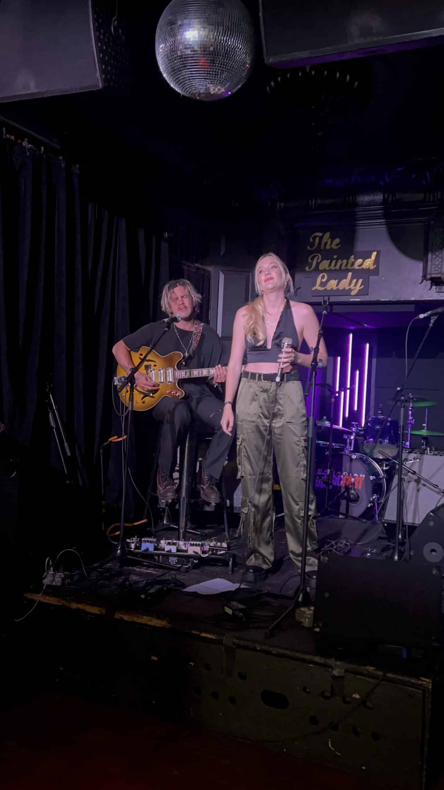 Chloé Caroline with guitar player
